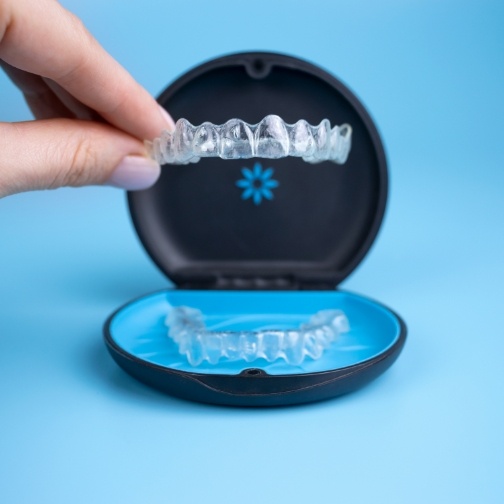 Person placing a clear aligner in its case