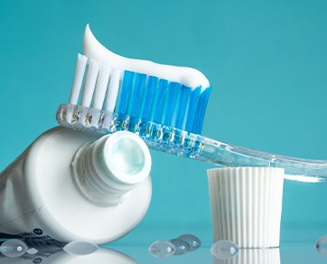 Toothbrush sitting on top of toothpaste tube