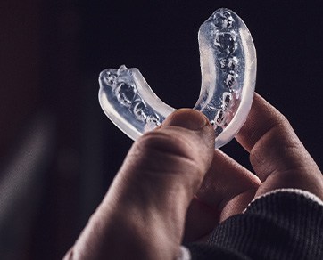 Hand holding an athletic mouthguard