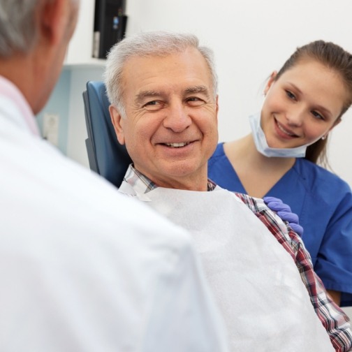 Senior man in dental chair smiling at his Fort Worth dentist