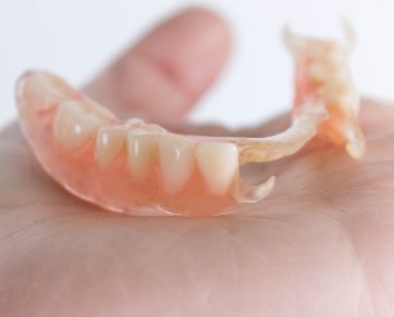 Hand holding a partial denture