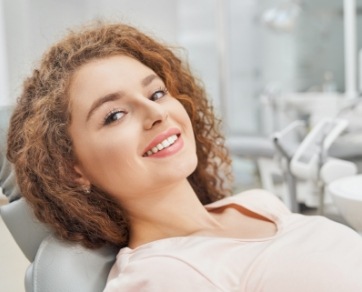 Smiling woman leaning back in dental chair