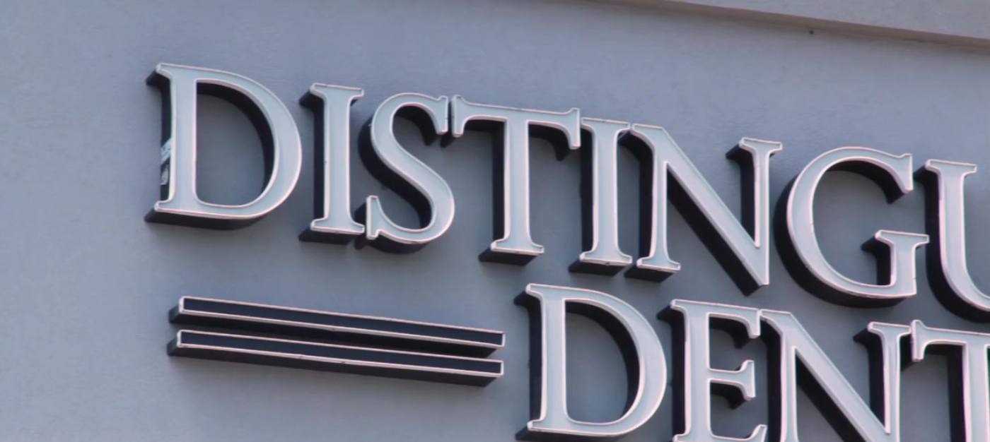Close up of Distinguished Dental sign outside of Fort Worth dental office