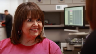 Woman in pink tee shirt smiling in dental office