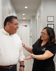 Dental team member showing a patient down the hallway