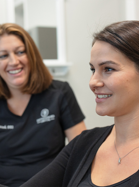 Doctor McIntosh smiling at young woman in dental chair