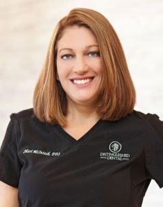 Doctor McIntosh smiling in black scrubs