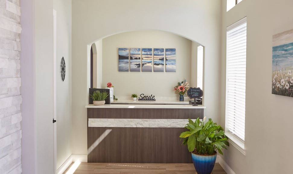 Front desk with beach themed artwork on wall behind it