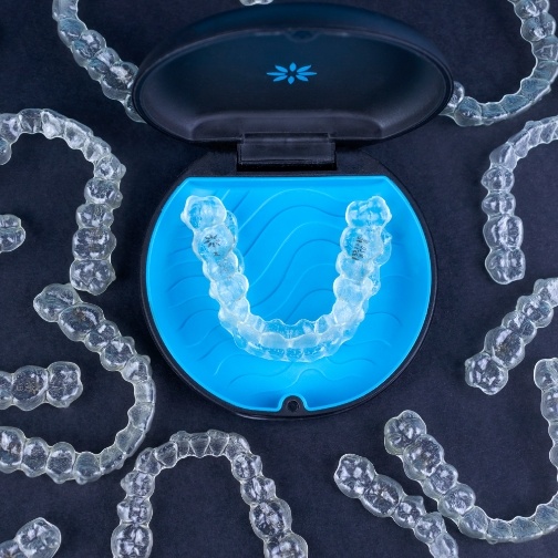 Several Invisalign clear aligners on a table