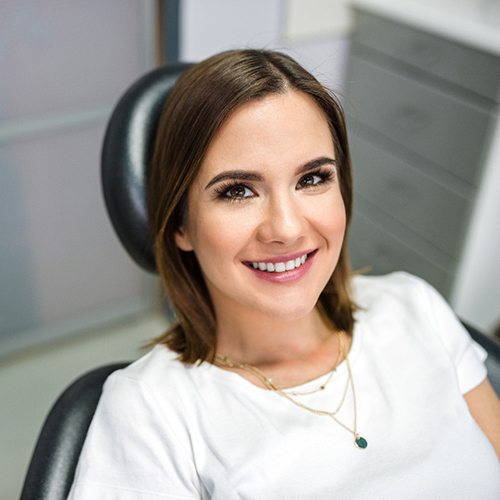 Woman sitting in dental chair and smiling