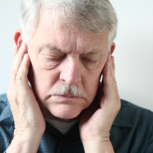 Man holding his temples in pain needing T M J treatment in Fort Worth