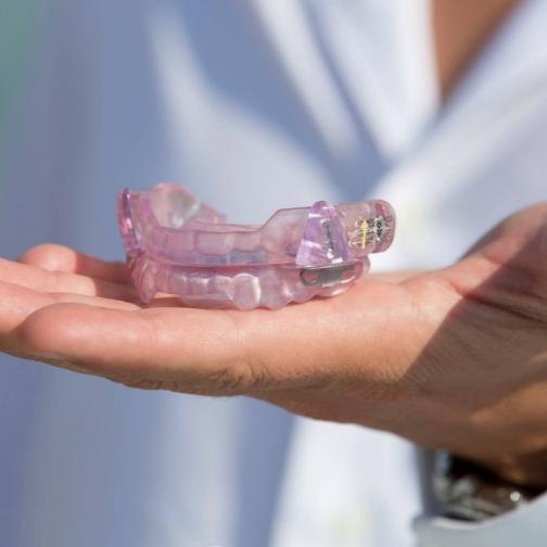 Dentist holding a light purple occlusal splint