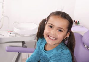 smiling little girl seated in the dentist's chair