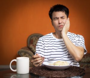 person holding mouth while eating