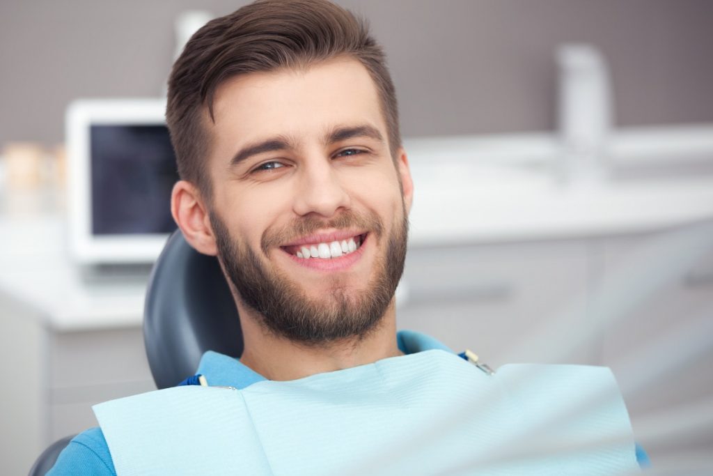 Smiling man in a blue shirt at the dentist