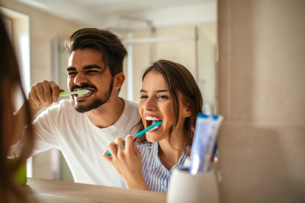 Man and woman brushing their teeth with tips from a dentist