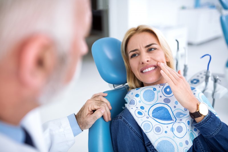 Woman talking to dentist about tooth pain