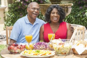 couple eating with dentures at a backyard get-together 