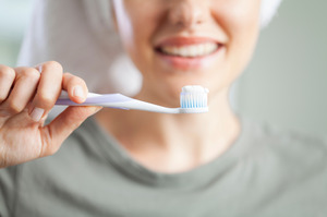 Close-up of a smiling woman holding a toothbrush
