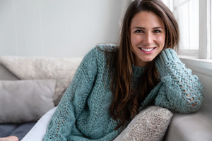 Woman leaning on a couch and smiling